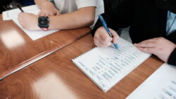 Teacher helping students at a table